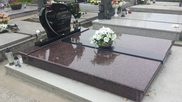 Dvojhrob z leštenej červenohnedej žuly so srdcovým pomníkom.