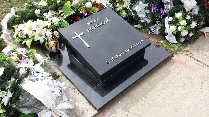 Kompaktný urnový hrob z tmavej žuly s jednoduchou krycou doskou.