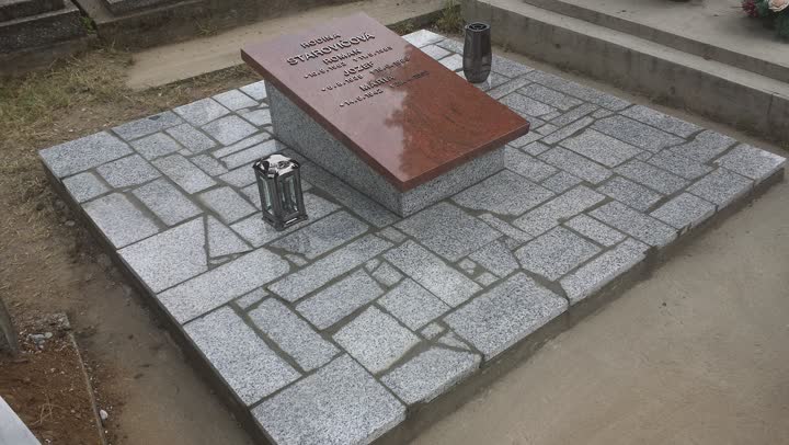 Urnové riešenie s nízkym žulovým pomníkom a kamennou dlažbou.